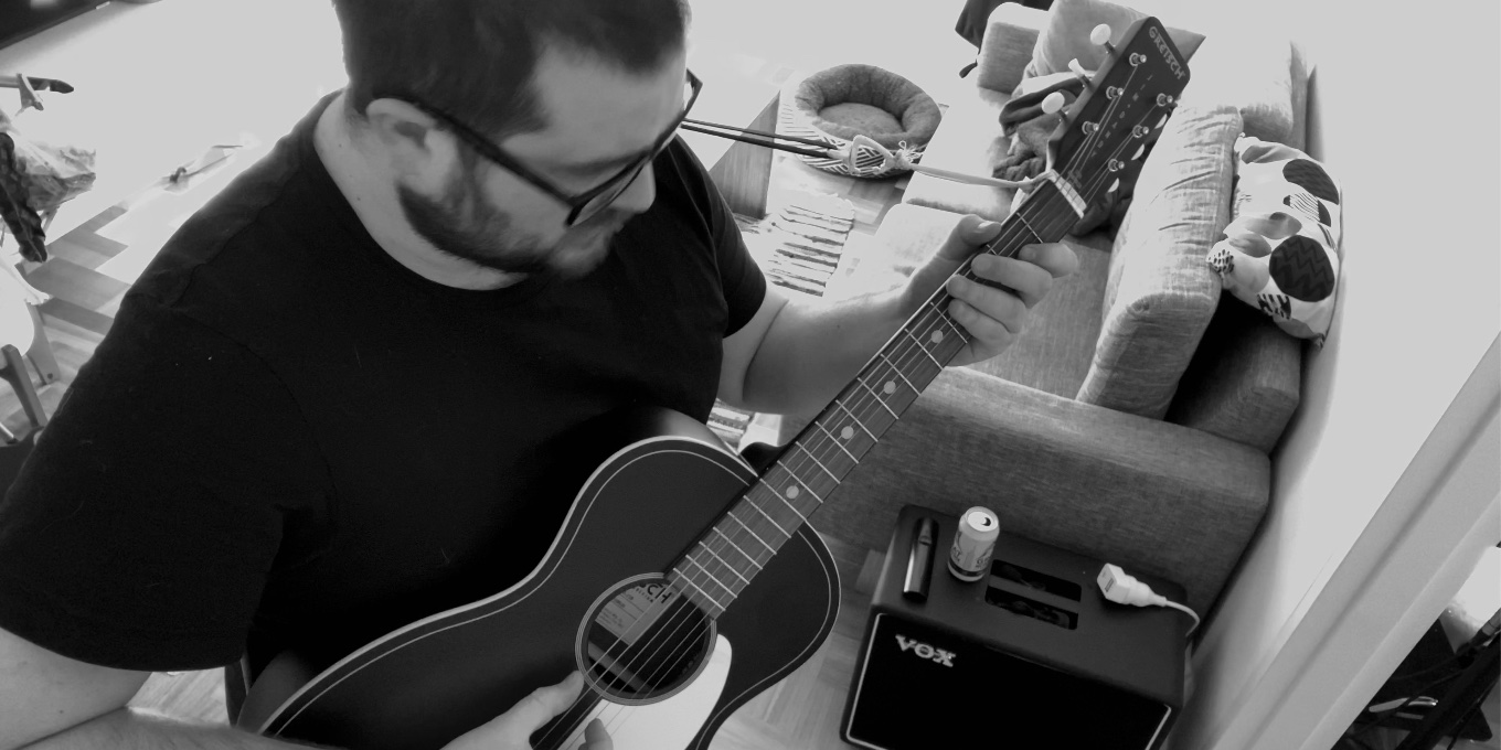 Black and white photo of a musician playing acoustic guitar